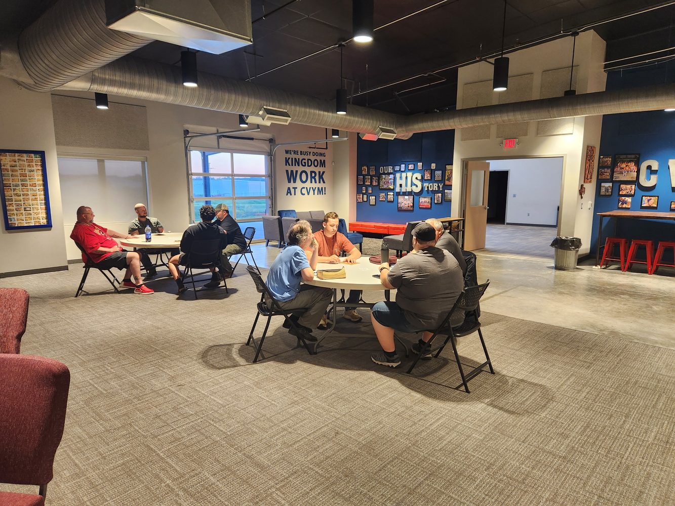 CV Men meeting in small groups around tables