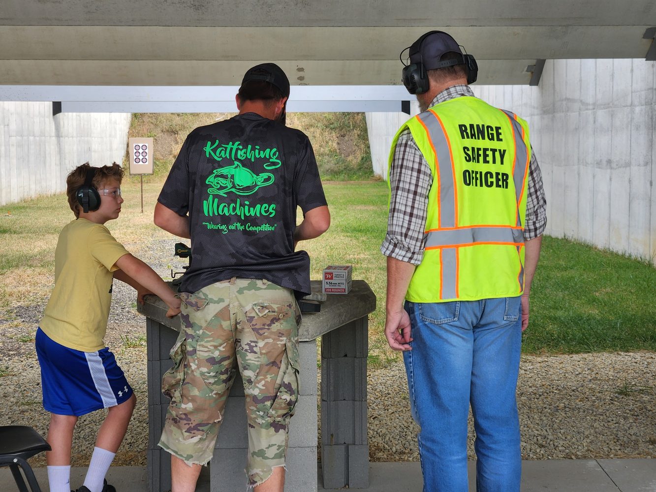 Adult instructing a young participant at Range Day